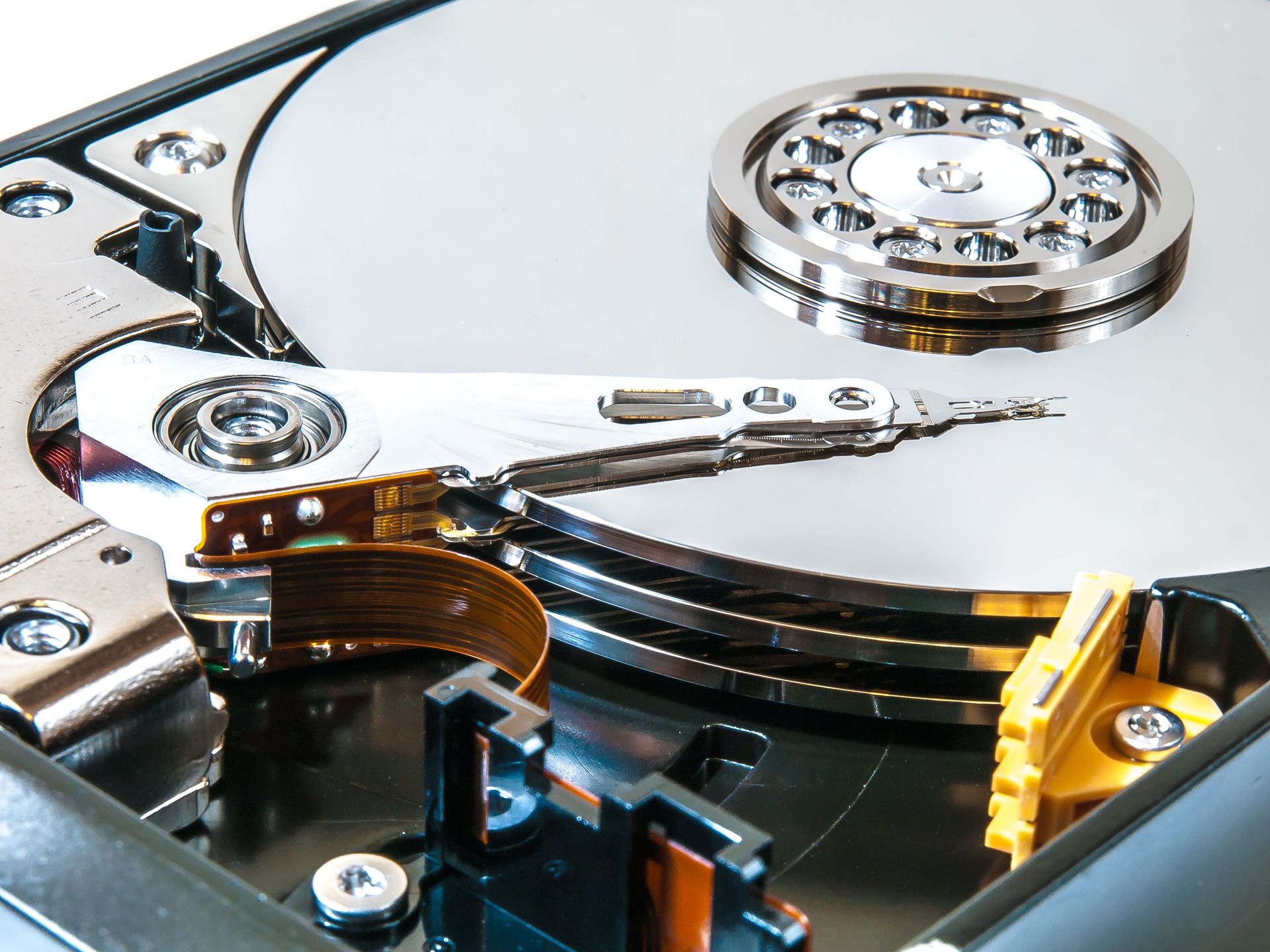 Detailed view of an open hard drive showing its internal mechanisms and disk platters.